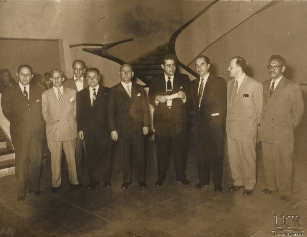 Fuente: I Congreso Universitario. En la fotografía se observa de derecha a izquierda: sin identificar; Lic. Víctor Manuel Obando; Lic. Rodrigo Facio Brenes; Lic. Fernando Baudrit Solera; Sr. Couture; Profesor Carlos Monge Alfaro; atrás de él; Sr. Daniel Quirós; Lic. Luis Demetrio Tinoco Castro; Sr. Fabio Fournier. En el Paraninfo Barrio González Lahmann, entrada a la Rectoría. 1946. En custodia en el Archivo Universitario.
